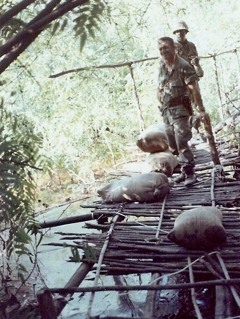 Sgt. Allen and another soldier hauling captured rice over bridge